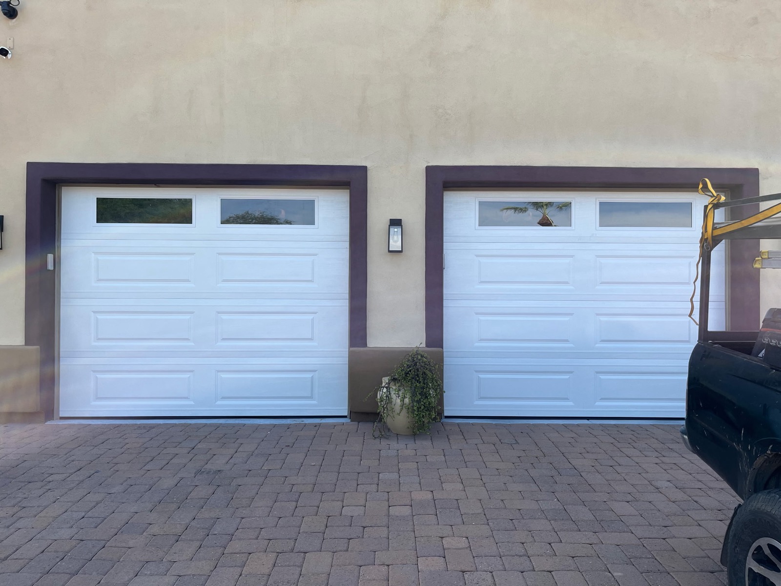 Twin single garage doors installed with maroon trim