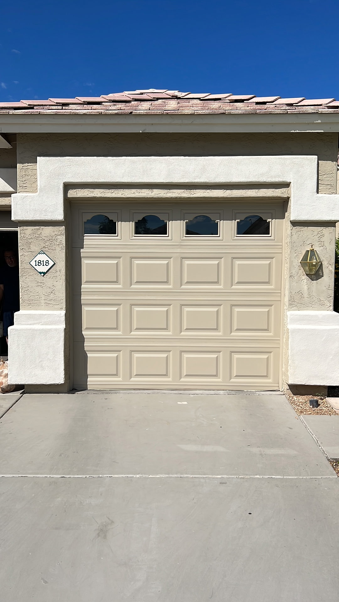 Almond carriage style garage door on tile-roof home