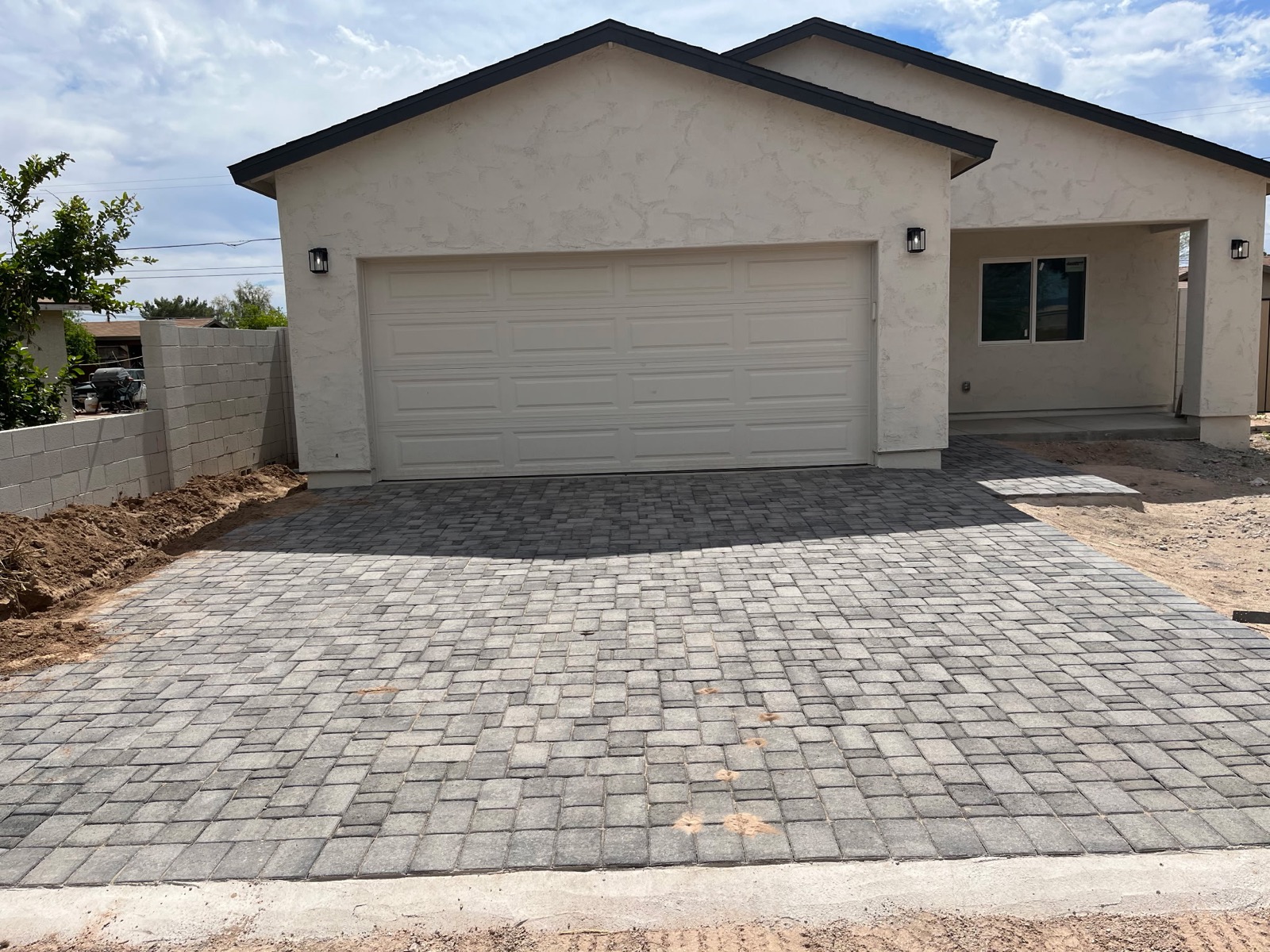 New build double garage door installation with paver driveway